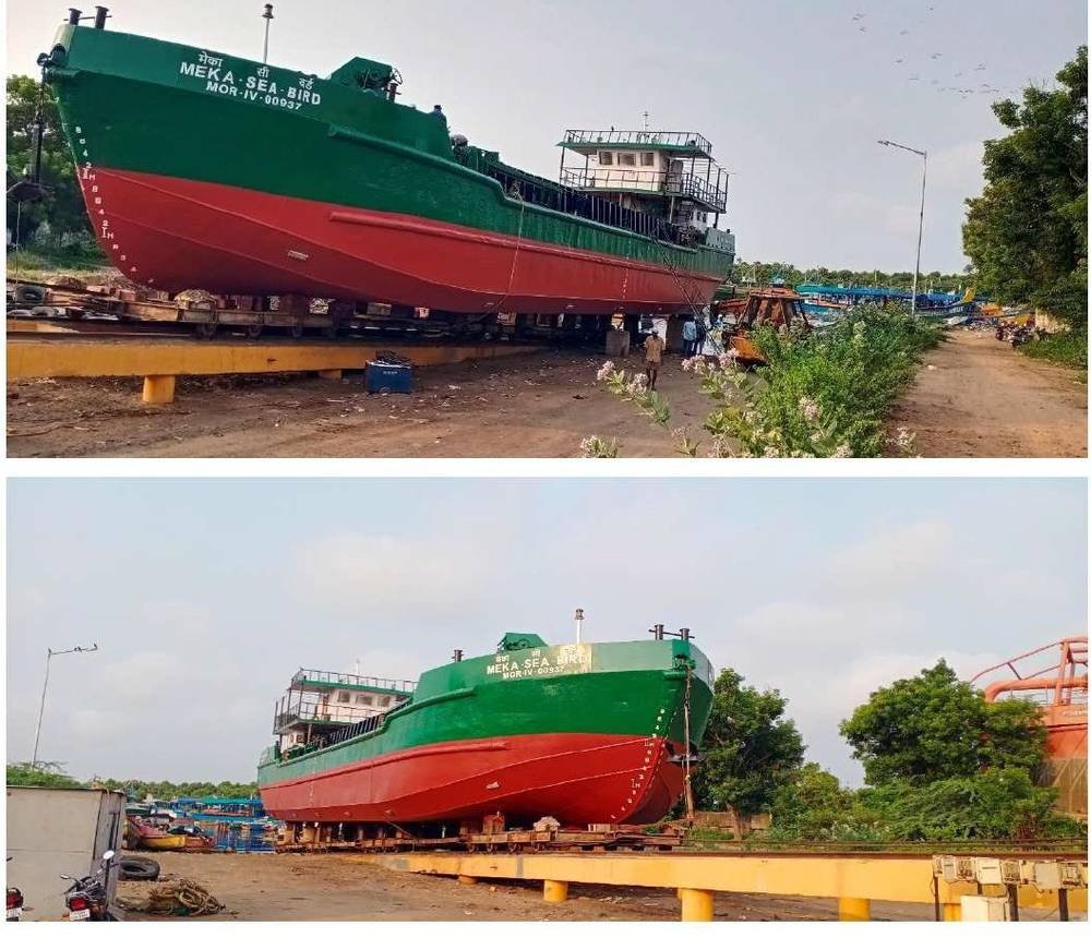 Newly fabricated green and red barge hull on the slipway