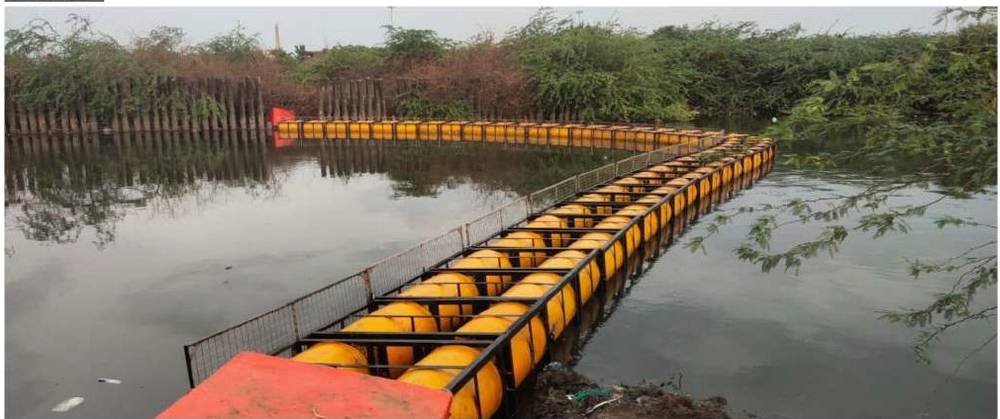 Floating trash barrier installed across a drainage canal