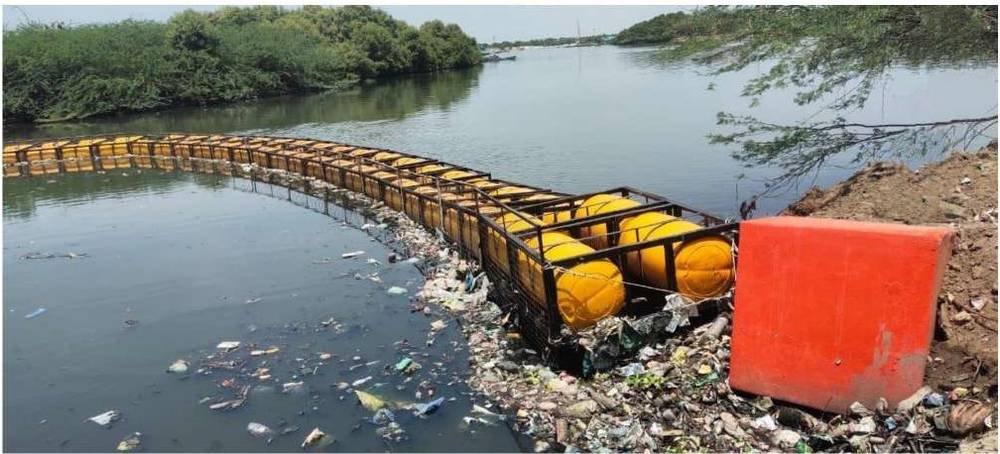 Cleared drainage canal after floating trash barrier installation